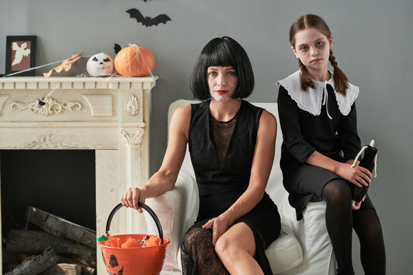 Girl and Her Mother in Halloween Costumes Sit in Chair